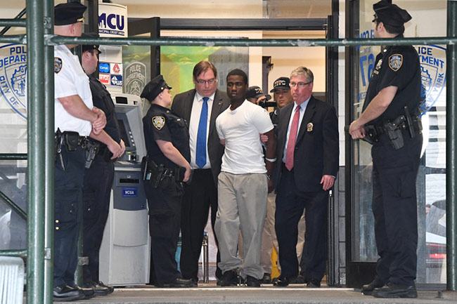 Justin Murrell is walked from the 67th Precinct on Friday. Photo: Paul Martinka